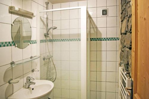 een badkamer met een wastafel en een douche met een spiegel bij Appart Saint-Antoine Morzine vue soleil jardin calme parking 2 à 4 pers in Morzine