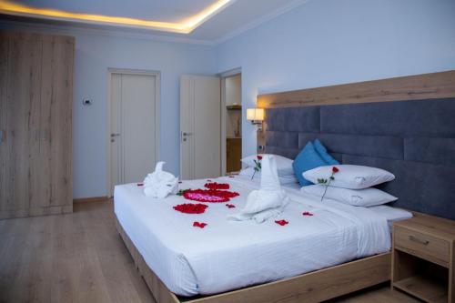 a bedroom with a white bed with red roses on it at Aselefech Merga Hotel and Spa in Addis Ababa