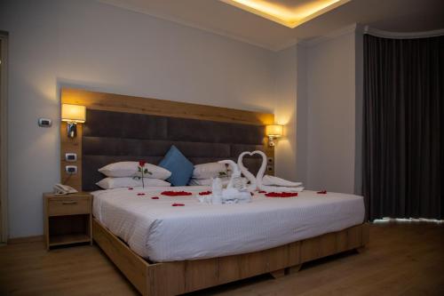 a bedroom with a large bed with red roses on it at Aselefech Merga Hotel and Spa in Addis Ababa