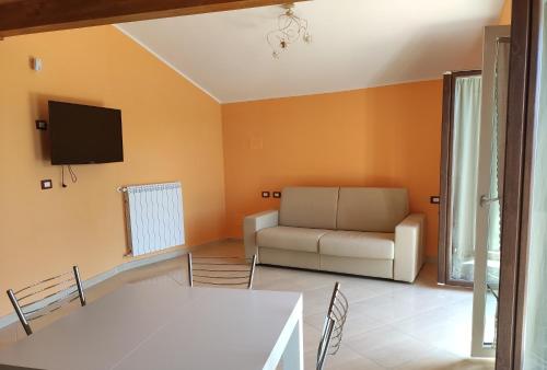Una sala de estar con un sofá y un televisor. en DA ELENA, en Castel di Sangro