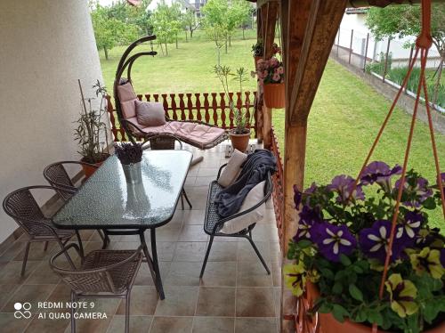 un patio con mesa, sillas y flores en Liget Fruit Garden, en Zalakaros