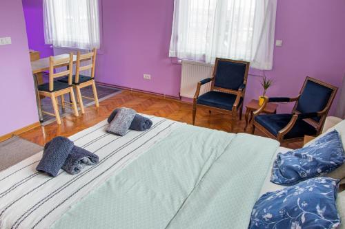a bedroom with a large bed with two chairs at Apartman Gloria 3 in Senjak (historical)