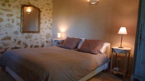 1 dormitorio con 1 cama y 2 mesas con lámparas en Chambres d'Hôtes La Treille, en Ligardes