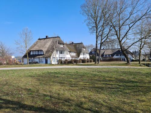 a large white house with a thatched roof at Das Landhaus am Haff B10 in Stolpe