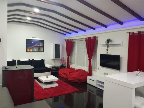 uma sala de estar com cortinas vermelhas e um sofá em vila Nikolaj em Niš
