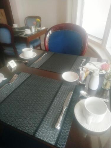 a table with a chair and a table with plates at The Gatsby Blackpool - Formerly The Windsor in Blackpool