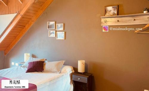 1 dormitorio con cama y escalera en M I A L M A Departamento Turistico en San Martín de los Andes