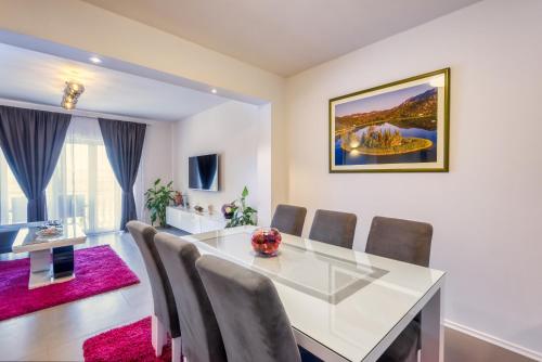 a dining room with a white table and chairs at Apartment Sea bass Neretva in Ploče