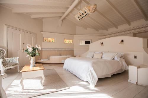 ein weißes Schlafzimmer mit einem Bett und einer Badewanne in der Unterkunft Hotel Casablanca Spa & Wine in Casablanca