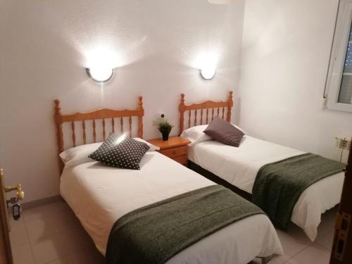 twee bedden in een kleine kamer met bij Albergue Cervera de Pisuerga in Cervera de Pisuerga