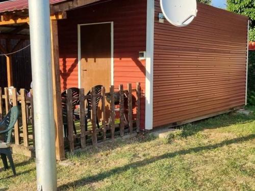 a fence in front of a house with chairs at Ferienbungalow Tinka in Štúrovo