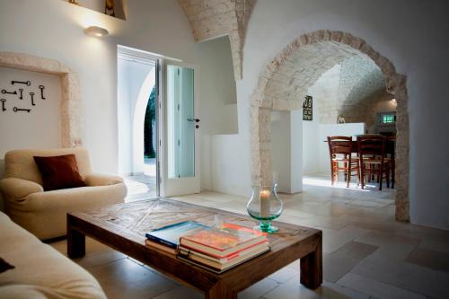 una sala de estar con una mesa con libros y una vela en La Vecchia Tabaccheria B&B, en Ostuni