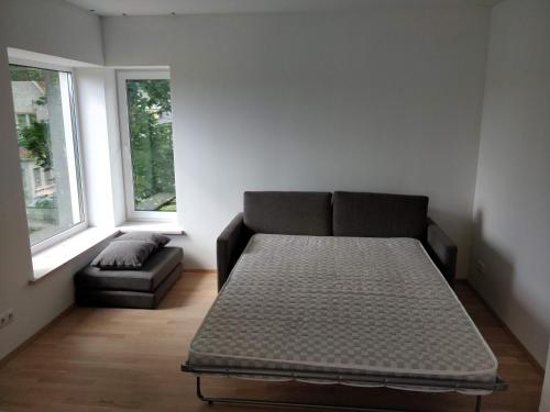 a room with a bed and a couch and two windows at Laheveere in Värska