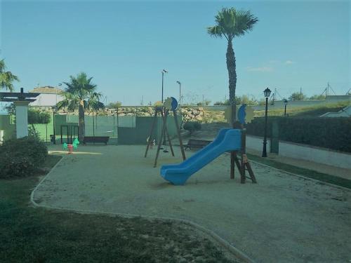 um parque infantil com um escorrega azul num parque em Casa Brisa Marina Vera em Vera