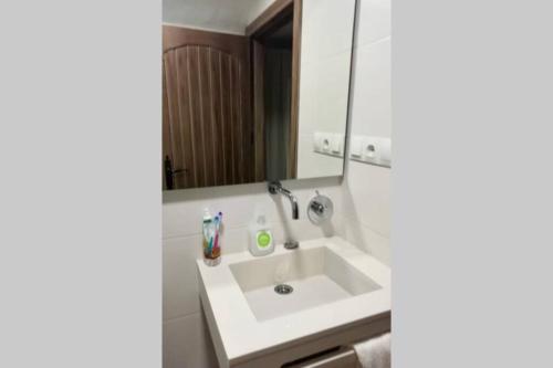 a bathroom with a white sink and a mirror at Cueva de Ramón y Elvira in Cuevas del Campo