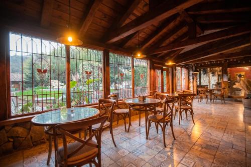 a restaurant with tables and chairs in a room with windows at Hotel Casablanca Spa & Wine in Casablanca