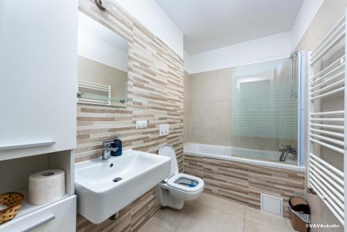 a bathroom with a sink and a toilet and a tub at Apartament Mini Palais Brasov in Braşov