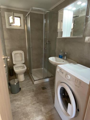 a bathroom with a washing machine and a sink at Soldatos Stone House in Katokhórion