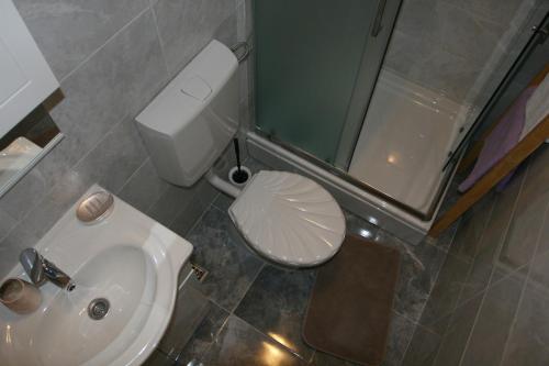 een badkamer met een wit toilet en een wastafel bij Apartman Mare in Makarska