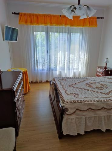 a bedroom with a bed and a large window at Apartamento do Paim in Ponta Delgada