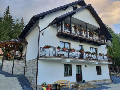 a white house with balconies and tables at Casa Sofia Bucovina in Ciumîrna