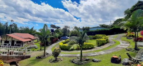 a garden with palm trees and a winding road at Finca Villa Elenita in Sasaima