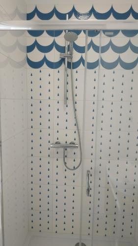 a shower with a blue and white shower curtain at Dom na Klifie in Międzyzdroje