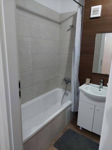 a bathroom with a white tub and a sink at Apartament Ambrus in Sighişoara