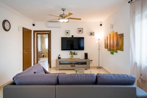 a living room with a blue couch and a tv at Villa Clara in Alberobello