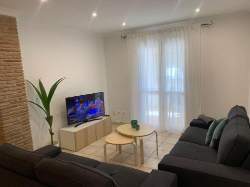 een woonkamer met een bank, een tv en een tafel bij apartamento centrico silencioso in Nerja