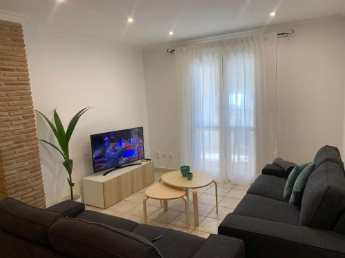 salon z kanapą, telewizorem i stołem w obiekcie apartamento centrico silencioso w mieście Nerja