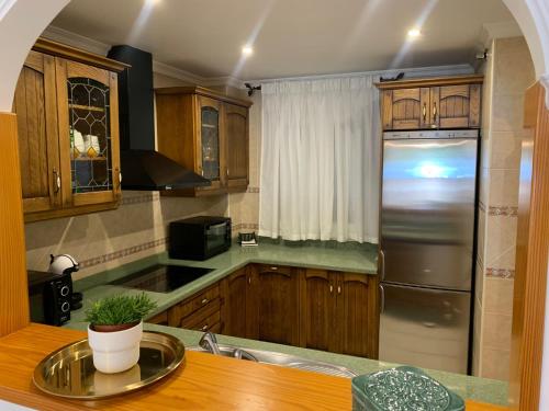kuchnia z drewnianymi szafkami i lodówką ze stali nierdzewnej w obiekcie apartamento centrico silencioso w mieście Nerja