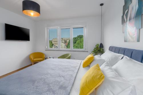 1 dormitorio con 1 cama blanca grande con almohadas amarillas en Sylvia Center Apartment, en Pula