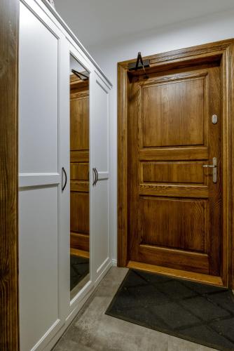 a hallway with a wooden door and a mirror at Krzywe Zwierciadło in Mrągowo