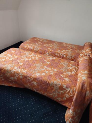 a bed with a comforter on top of it at Hotel du Commerce et de Navarre in Lourdes