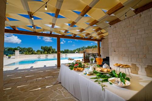 a buffet table on a patio with a pool at Villa Clara in Alberobello