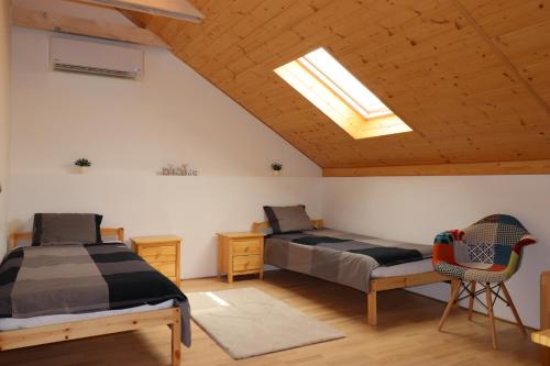 a bedroom with two beds and a skylight at Apartmán Sebina in Drnholec