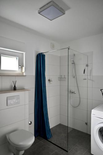 a bathroom with a shower with a toilet and a sink at Apartment First Row in Komarna