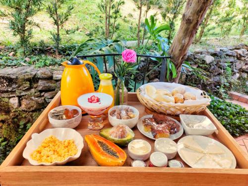 een houten blad gevuld met verschillende soorten voedsel bij Pousada Villa Magna - Casa 4 in Diamantina