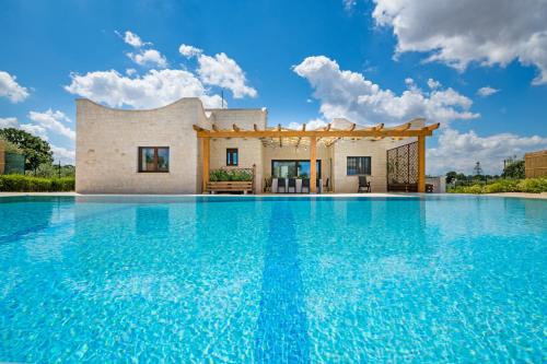 a villa with a swimming pool in front of a house at Villa Clara in Alberobello