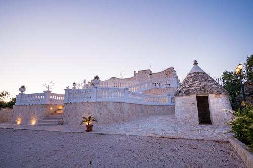 a large white building with a fence and stairs at Villa Clara in Alberobello