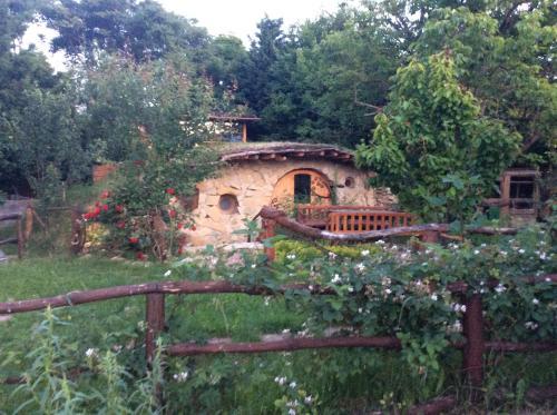 a stone house in a garden with a fence at Fűtetős Dombház in Üröm