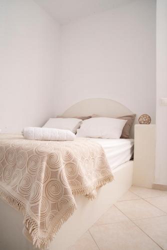 a white bed with white sheets and pillows at Kanellis Studios in Avlemonas