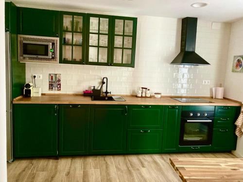 a green kitchen with green cabinets and a sink at Casa Mercedes y Pepe in Aracena