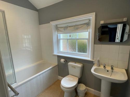 a bathroom with a toilet and a sink and a tub at Croxton House in Kirmington