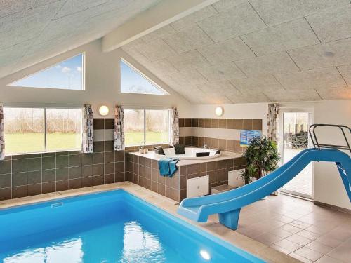 a indoor swimming pool with a slide in a house at 24 person holiday home in Hasselberg in Kappeln