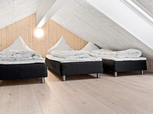 two beds sitting in a room with an attic at 24 person holiday home in Hasselberg in Kappeln