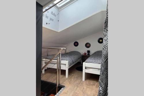 Cette chambre mansardée comprend 2 lits. dans l'établissement Superbe appartement rénové avec accès direct plage, à Bretignolles-sur-Mer