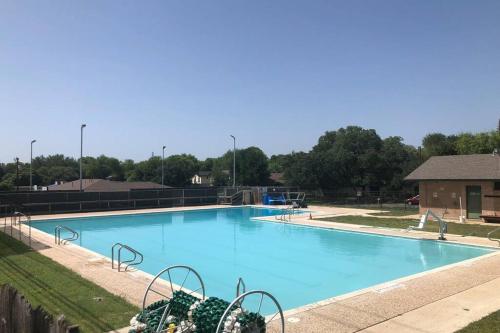 a large blue swimming pool with trees in the background at CYC Mega House with BBQ Gazebo in San Antonio