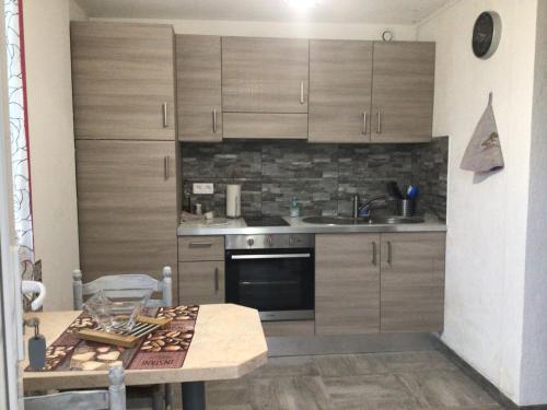 une cuisine avec des armoires en bois et une table en bois dans l'établissement mon petit paradis, à Saint-Blaise